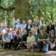 group photo from attendees on the June 2022 bus tour on Vancouver Island, standing in front of a large Sitka Spruce